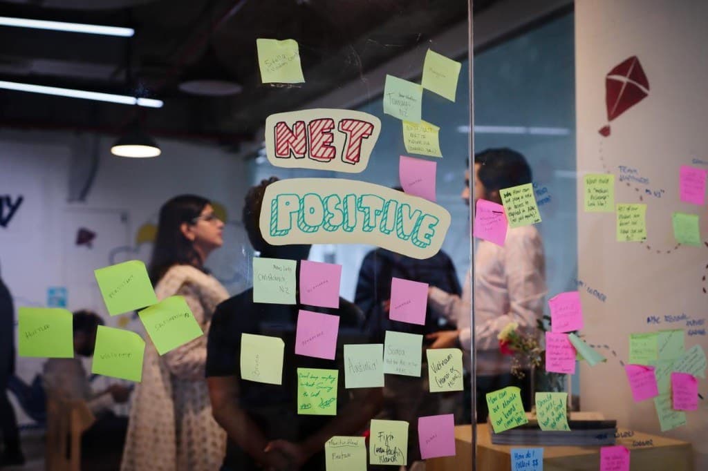 A collaborative planning session with Net Positive signage and sticky notes